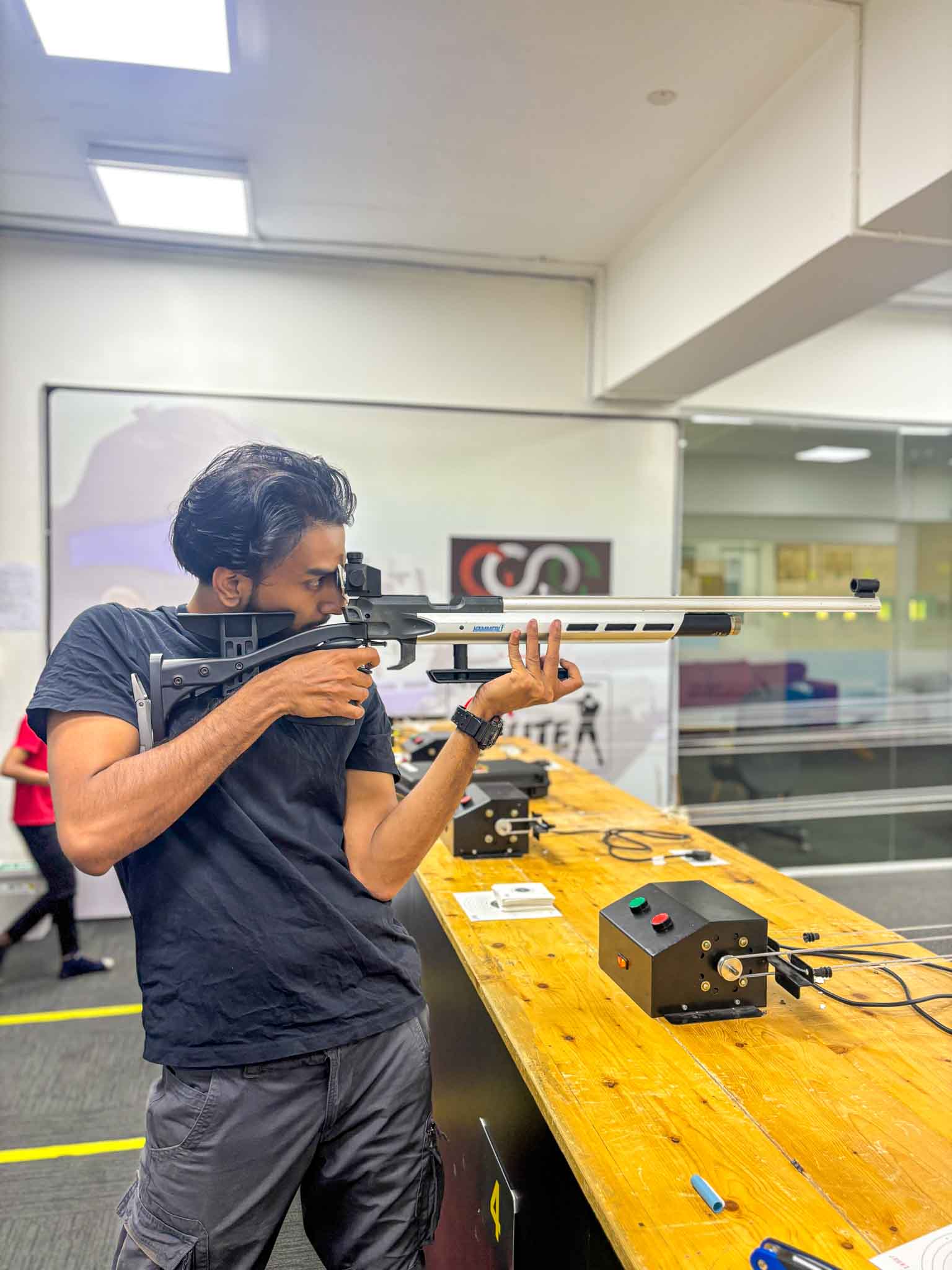 A male shooter preparing to fire with a rifle at the elite shooting club in Bengaluru.